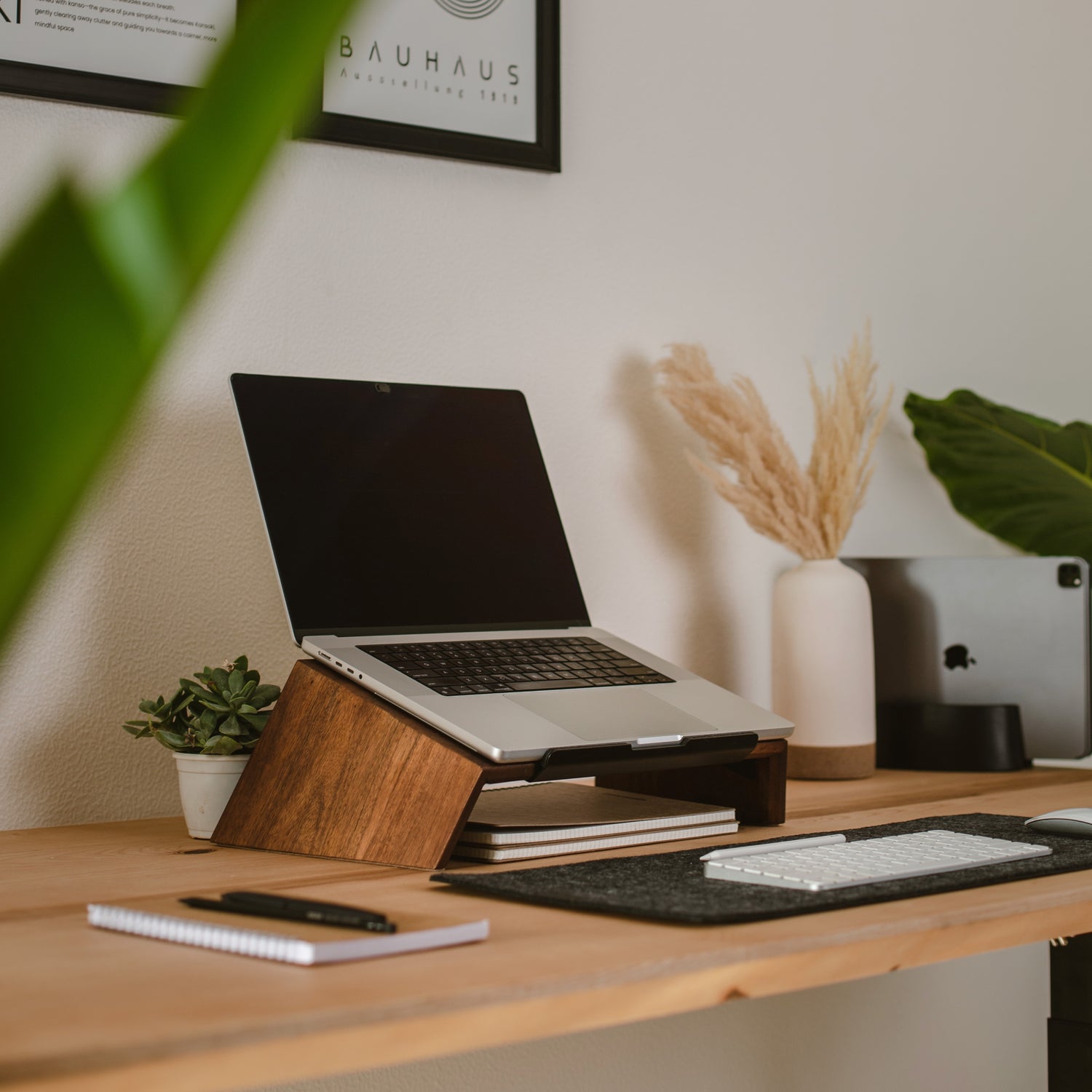 a clear desk with a wooden laptop stand, a laptop on it, japandi laptop stand, laptop riser,