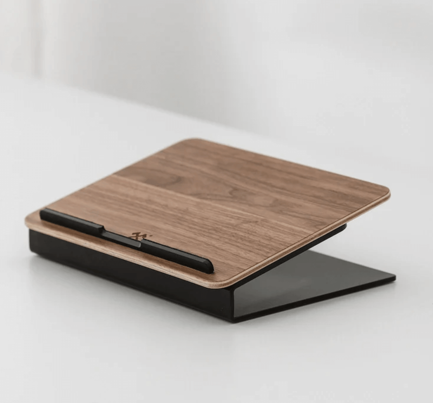 Minimal wooden laptop stand with black base and angled ergonomic design