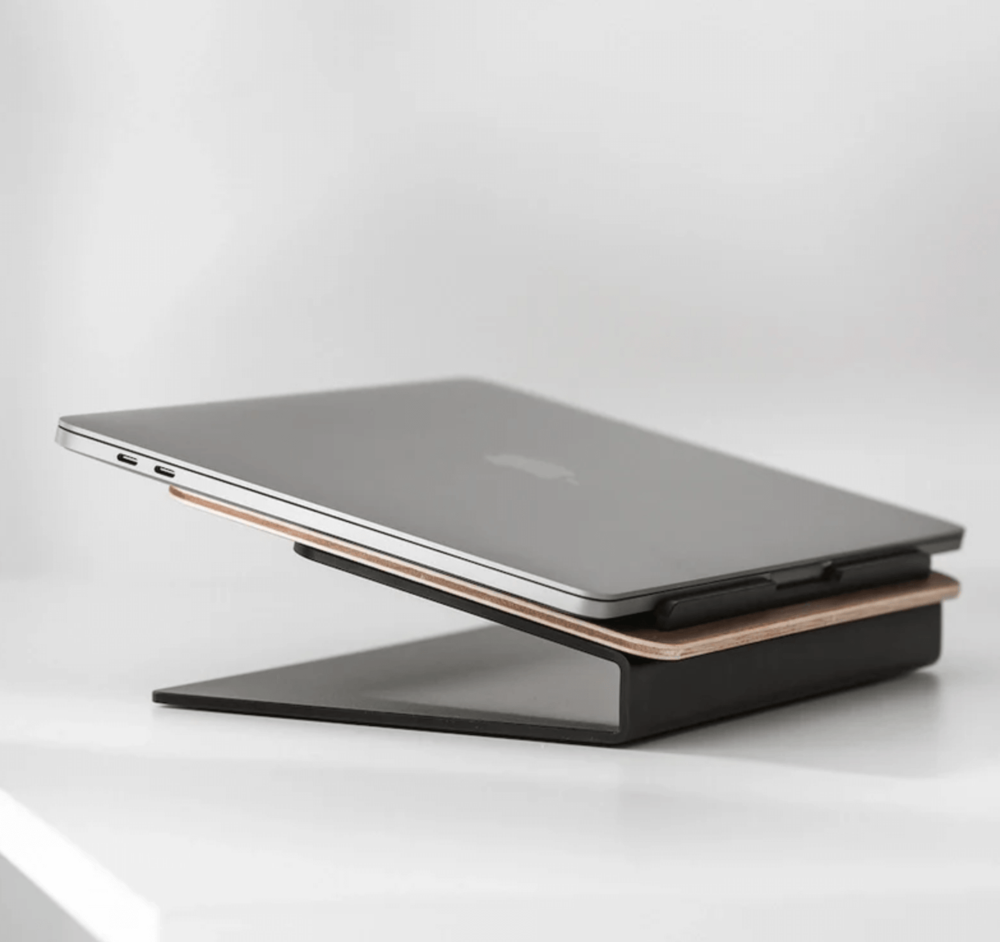 Modern desk accessory with Kansoki wooden laptop stand in black metal frame, elevating laptop for organised workspace