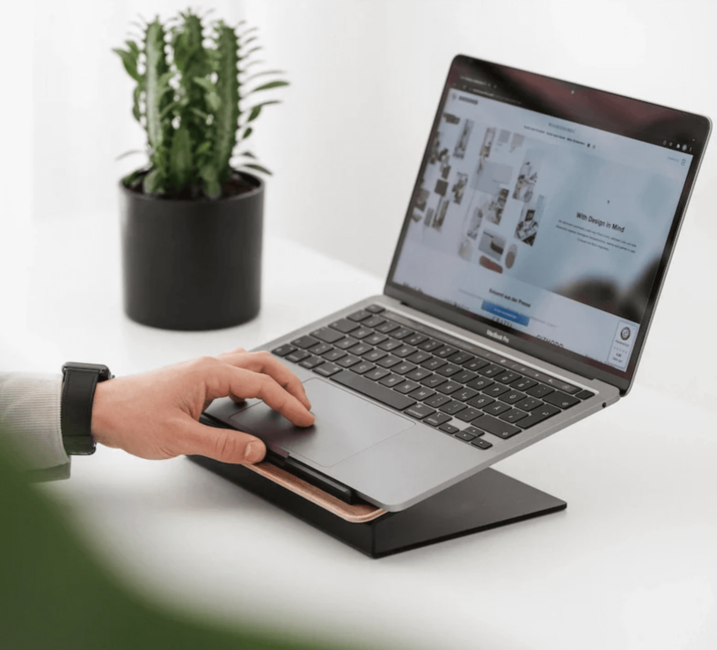 Person using a laptop on a stand, classic laptop stand, laptop riser, ergonomic laptop stands,
