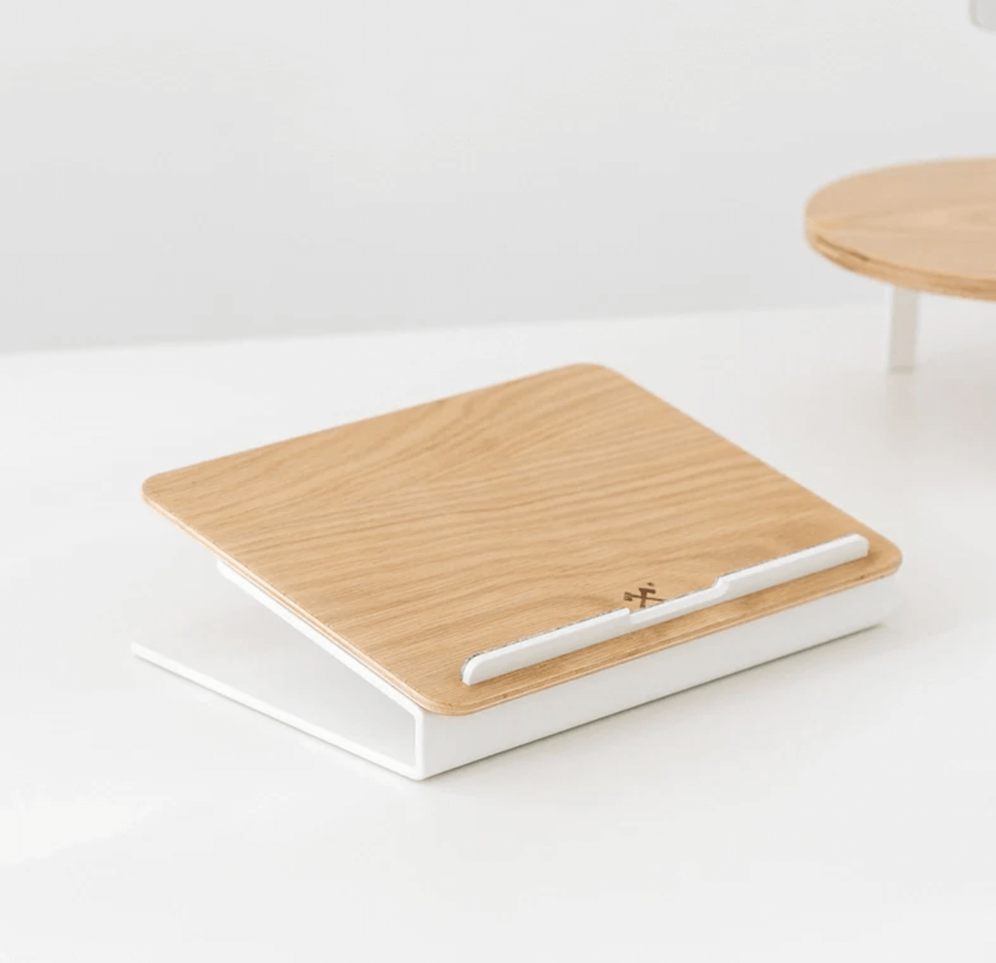 Kansoki wooden laptop stand with white metal base and felt strip for stable laptop support.