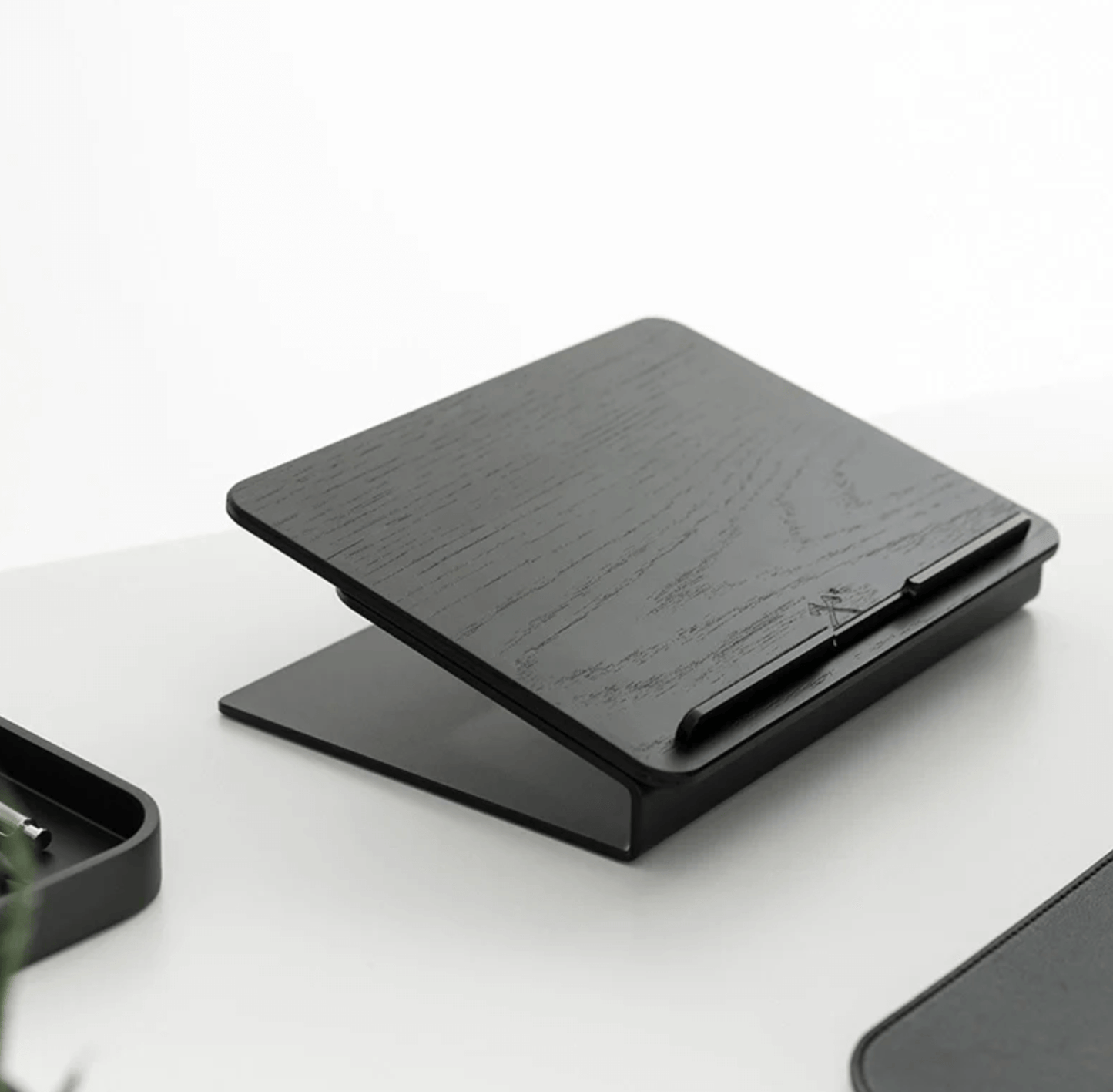 Black wooden laptop stand on a white surface, wooden laptop riser,