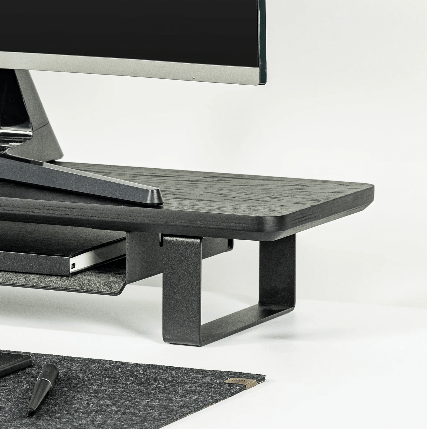 Black Monitoe Stand side angle shot with desk matt around