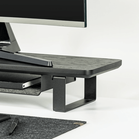 Black Monitoe Stand side angle shot with desk matt around