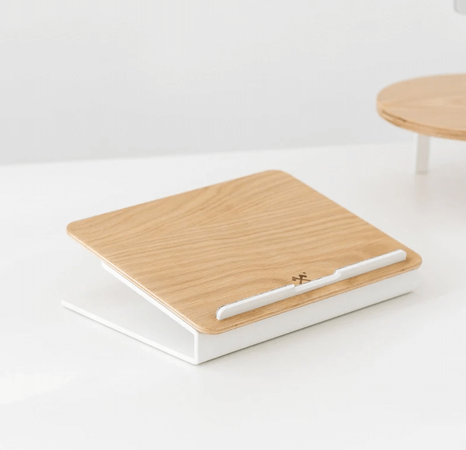 Kansoki wooden laptop stand with white metal base and felt strip for stable laptop support.