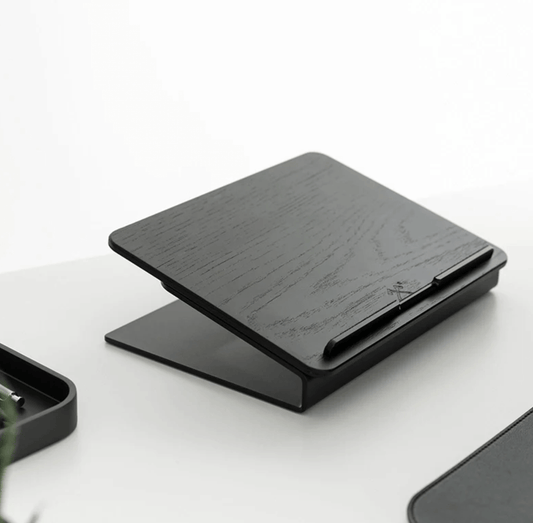 Black wooden laptop stand on a white surface, wooden laptop riser,